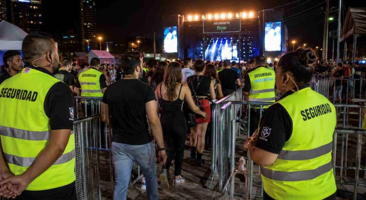 Personal de seguridad controlando el flujo de público en un concierto nocturno